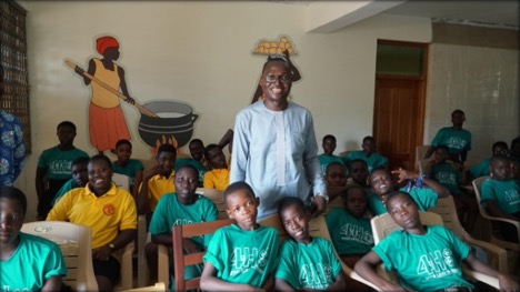Dr. Alex Yahw Adom surrounded by students